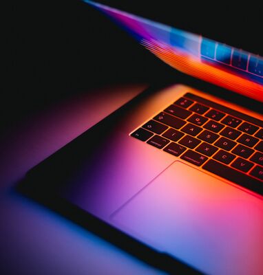 Laptop mit leuchtendem Bildschirm im Dunklen